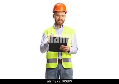 Male engineer with a safety vest and hardhat writing a on a clipboard and looking at camera isolated on white background Stock Photo