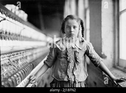 Cotton-Mill Worker, North Carolina by Lewis Hine (1874-1940), 1908. The photograph show a young girl of twelve or thirteen working in a cotton mill as child labor. Stock Photo