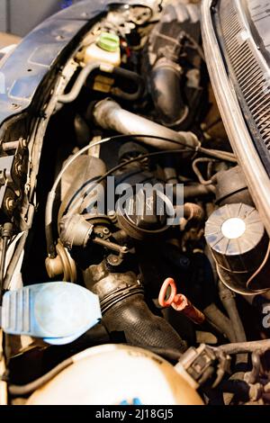 Dolyna, Ukraine September 17, 2021: Open car hood, motor and all parts for the operation of the engine of a Volkswagen bus, details close up. Stock Photo