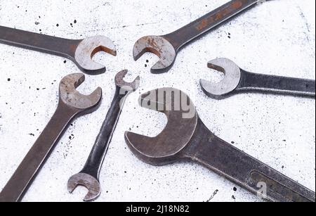 The photo shows various rusty wrenches on a light gray background Stock Photo