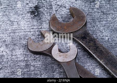 The photo shows various rusty wrenches on a gray background Stock Photo
