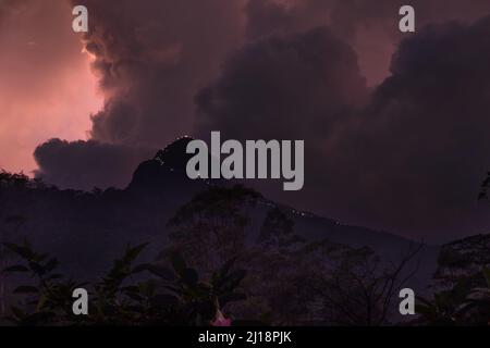 Adam's Peak is a 2243 m tall conical mountain located in central Sri Lanka - Sacred Mountain for four religions with a temple on the top. Twilight mou Stock Photo