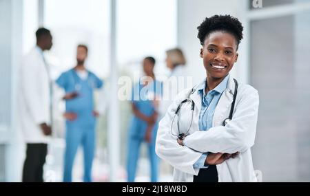 Its my mission to guide you towards better health. Portrait of a young doctor standing in a hospital. Stock Photo