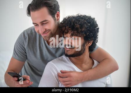 Pleased guy taking photos with his boyfriend Stock Photo