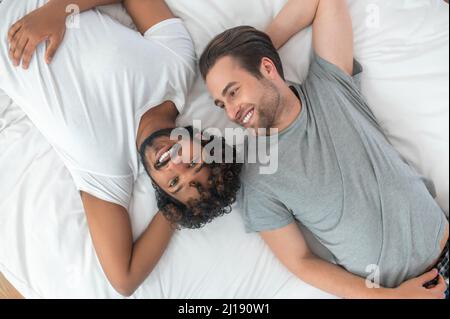 Joyful gay couple resting in their bedroom Stock Photo