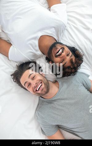 Happy gay couple resting in their bed Stock Photo