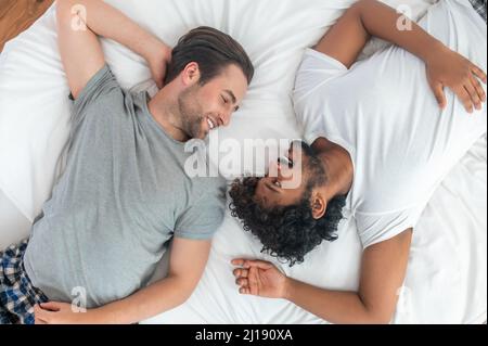 Two men in love lying in the bedroom Stock Photo