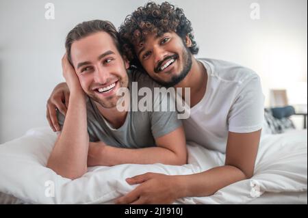 Romantic male hugging his happy Caucasian partner Stock Photo