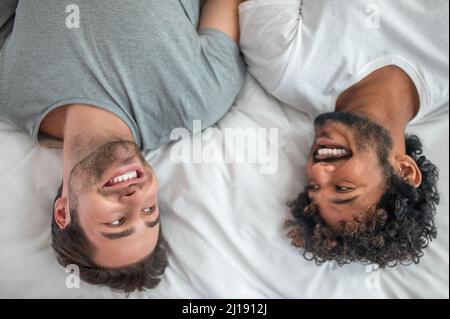 Happy gay couple lying in the bedroom Stock Photo