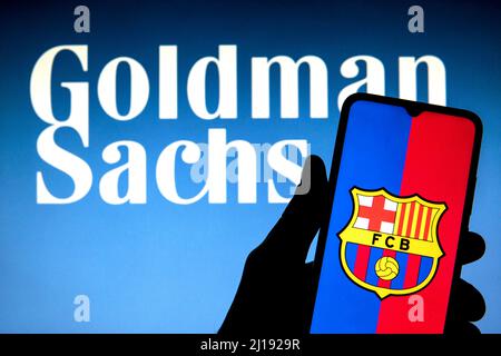 Spain. 23rd Mar, 2022. In this photo illustration a Football Club Barcelona (FCB) logo seen displayed on a smartphone with a Goldman Sachs Group logo in the background. (Credit Image: © Thiago Prudencio/SOPA Images via ZUMA Press Wire) Stock Photo