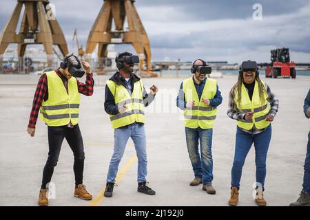 Multiracial workers dancing to music using virtual reality headsets at Freight Terminal Port - Focus on center men goggles Stock Photo