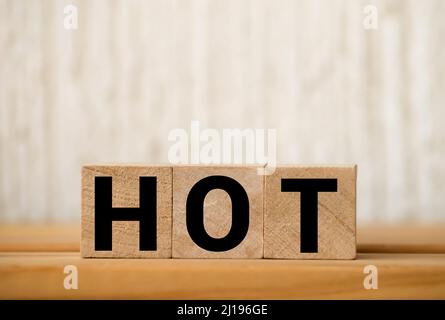 HOT word written on wooden blocks and placed on a yellow. Vacancy, sale and hot seat concept Stock Photo