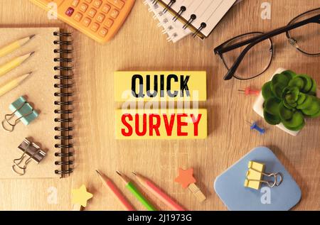 Quick Survey text written on a notebook with pencils. Stock Photo