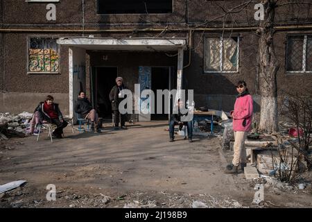 Mariupol, Ukraine. 23rd Mar, 2022. A family prepare to cook over an open fire outside their destroyed home in the embattled port city. The battle between Russian/Pro Russian forces and the defencing Ukrainian forces lead by Azov battalion continues in the port city of Mariupol. Credit: SOPA Images Limited/Alamy Live News Stock Photo