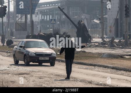 Mariupol, Ukraine. 23rd Mar, 2022. A man attempts to hitchhike out of Mariupol after a protracted seige left much of the city in ruins. The battle between Russian/Pro Russian forces and the defencing Ukrainian forces lead by Azov battalion continues in the port city of Mariupol. Credit: SOPA Images Limited/Alamy Live News Stock Photo