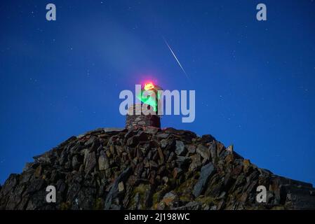 Spectator scanning horizon at Snowdon Summit Cairn Stock Photo