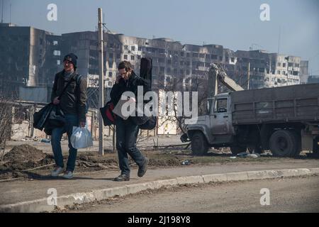 Mariupol, Ukraine. 23rd Mar, 2022. With a cardboard sign reading 'Volodarsk', two young men attempt to hitchhike from the ruins of Mariupol to Russia. The battle between Russian/Pro Russian forces and the defencing Ukrainian forces lead by Azov battalion continues in the port city of Mariupol. (Photo by Maximilian Clarke/SOPA Images/Sipa USA) Credit: Sipa USA/Alamy Live News Stock Photo