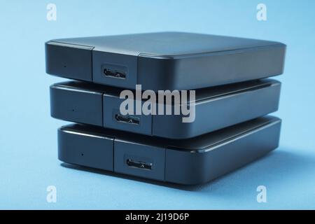 A stack of hard drives on a blue background. Stock Photo