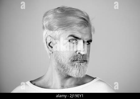 Portrait of blonde serious man has beard and mustache, looks seriously, isolated. Barber with long beard and moustache in barbershop. Bearded man. Stock Photo