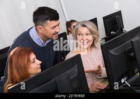 Male teacher helping mature women Stock Photo
