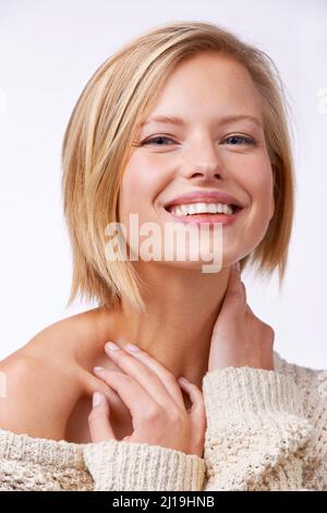 Shes simply beautiful. Studio portrait of a beautiful smiling woman in a sweater. Stock Photo