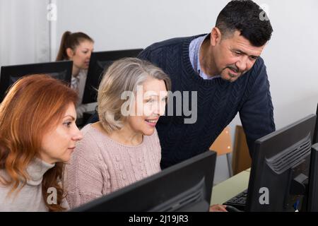 Mature people working together on computer Stock Photo
