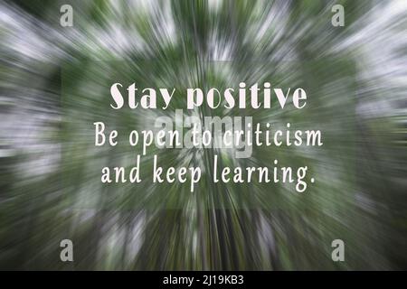 Motivational and inspirational quote on blurry bamboo trees zoom motion effect background - Stay positive, be open to criticism and keep learning. Stock Photo