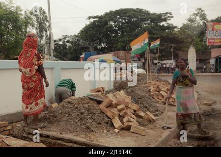 Women working manual labour at a roadside construction site in Kolaghat town, Purba Medinipur, West Bengal, India. Stock Photo