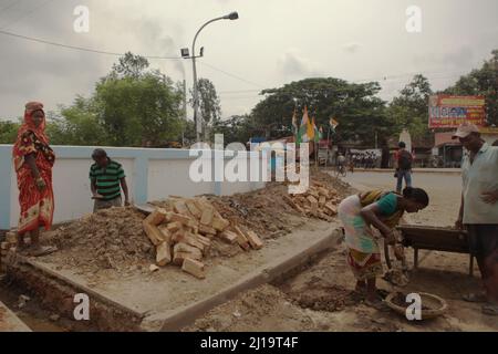 Women working manual labour at a roadside construction site in Kolaghat town, Purba Medinipur, West Bengal, India. Stock Photo