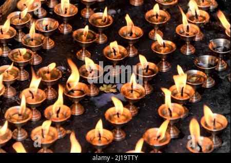 Worshippers light butter lamps, candles, fires for religious ceremonies, temple complex, Kathmandu, Kathmandu Valley, Nepal Stock Photo