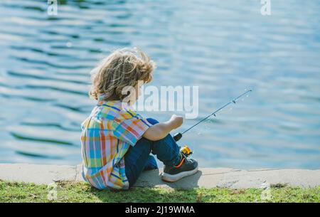 Child with fishing rod on wooden pier Stock Photo by ©Tverdohlib