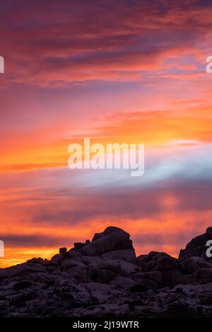 Incredible pink, orange sunset seen over desert landscape in Mojave Desert with purple, pastel tones. Stock Photo