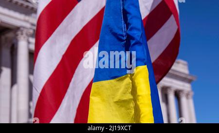 Close up of US, Ukraine flags overlapping with capitol building in background Stock Photo