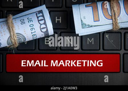 Email marketing text on space bar with money and laptop background. Online business concept Stock Photo