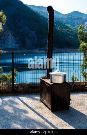Oymapinar Dam Over Manavgat River. Pots on an iron wood stove, corn is cooking on the stove. Selective focus stove Stock Photo
