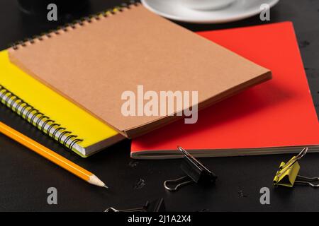 Three notepads on a black table close up Stock Photo