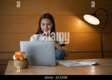 businesswoman accountant analyst documents looking at laptop computer screen doing online trade market tech research thinking working sit at home Stock Photo