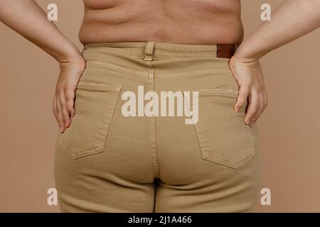 Closeup of lady with large sides with hands pulling up leggings pants on  beige background. Body positive. Accepting who you are. Tight clothes. Need  Stock Photo - Alamy