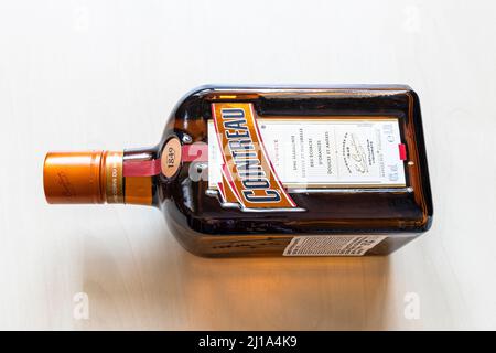 Moscow, Russia - March 20, 2022: lying bottle of french Cointreau liqueur on pale table. Cointreau is orange flavoured triple sec liqueur produced in Stock Photo