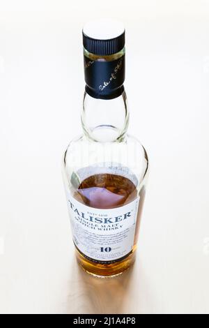 Moscow, Russia - March 20, 2022: bottle of 10 years old Talisker island single malt Scotch whisky on pale table. Talisker 10 year old whisky has been