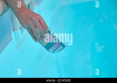 Woman hand filling ph and cl kit with pool water to test the quality. Stock Photo