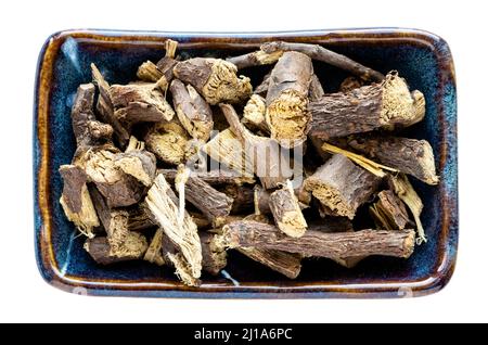 top view of dried Liquorice roots in bowl isolated on white background Stock Photo