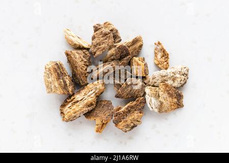 several chopped dried burdock roots close up on gray plate Stock Photo