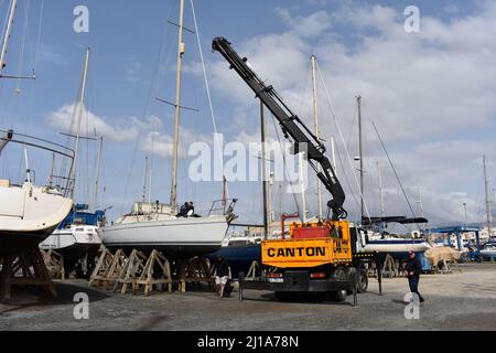 Yacht mast being removed by a crane, Almerimar marina boatyard, Almeria, Spain Stock Photo