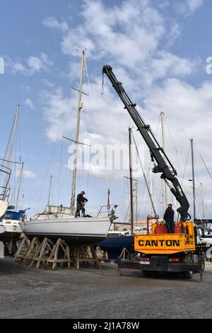 Yacht mast being removed by a crane, Almerimar marina boatyard, Almeria, Spain Stock Photo