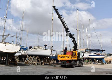 Yacht mast being removed by a crane, Almerimar marina boatyard, Almeria, Spain Stock Photo