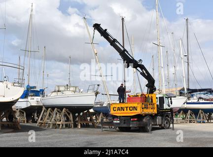 Yacht mast being removed by a crane, Almerimar marina boatyard, Almeria, Spain Stock Photo