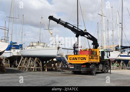 Yacht mast being removed by a crane, Almerimar marina boatyard, Almeria, Spain Stock Photo