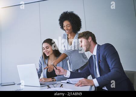 Working hard for the top results they strive for. Shot of a diverse group of businesspeople working together on a laptop in an office. Stock Photo