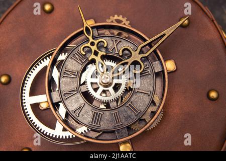 Close-up of a clock mechanism with cogs, watch face and hands as decoration on a leather bag. Stock Photo
